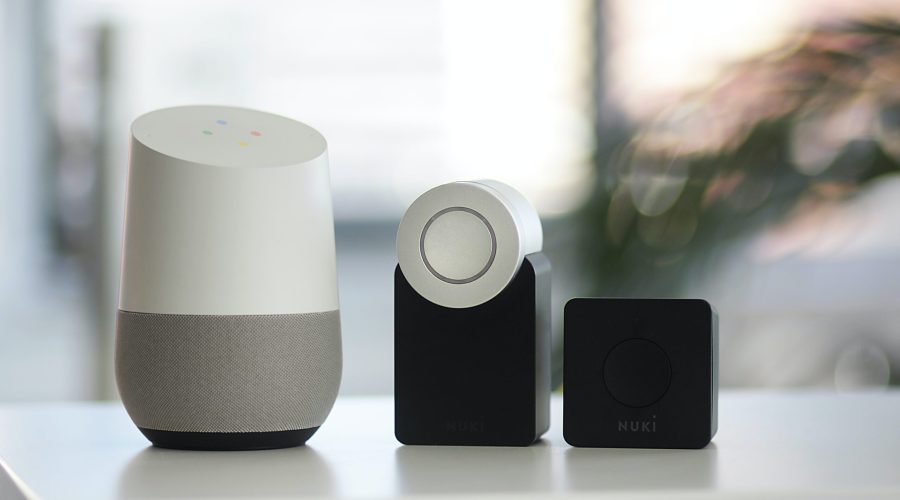 white and gray Google smart speaker and two black speakers