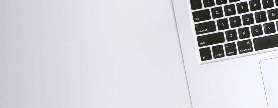 Free Aerial view of a sleek laptop keyboard on a clean, white surface, ideal for tech backgrounds. Stock Photo