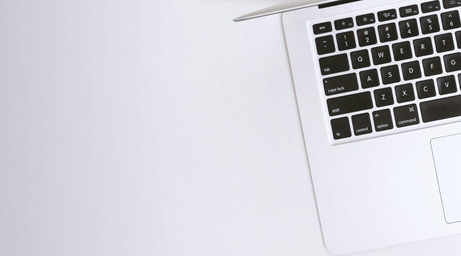 Free Aerial view of a sleek laptop keyboard on a clean, white surface, ideal for tech backgrounds. Stock Photo