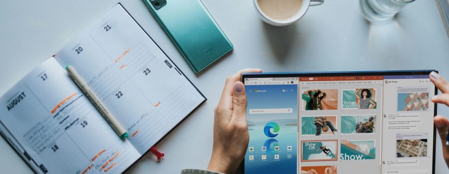 person using Windows 11 computer beside white ceramic mug on white table