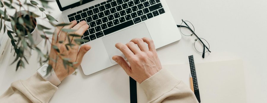 Free An overhead view of a person working on a laptop in a minimalist home office setting. Stock Photo