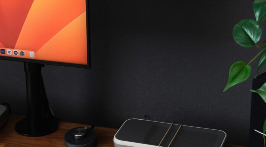 a desk with a laptop, keyboard, mouse and a monitor