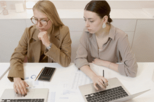 two women with laptops